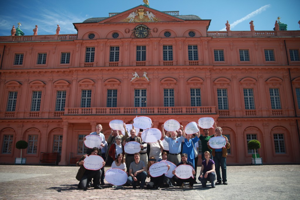 Aktive der Kampagne zeigen ihre Botschaften für ein Leben ohne Geheimdienst auf dem Schlosshof von Rastatt, Juni 2014.